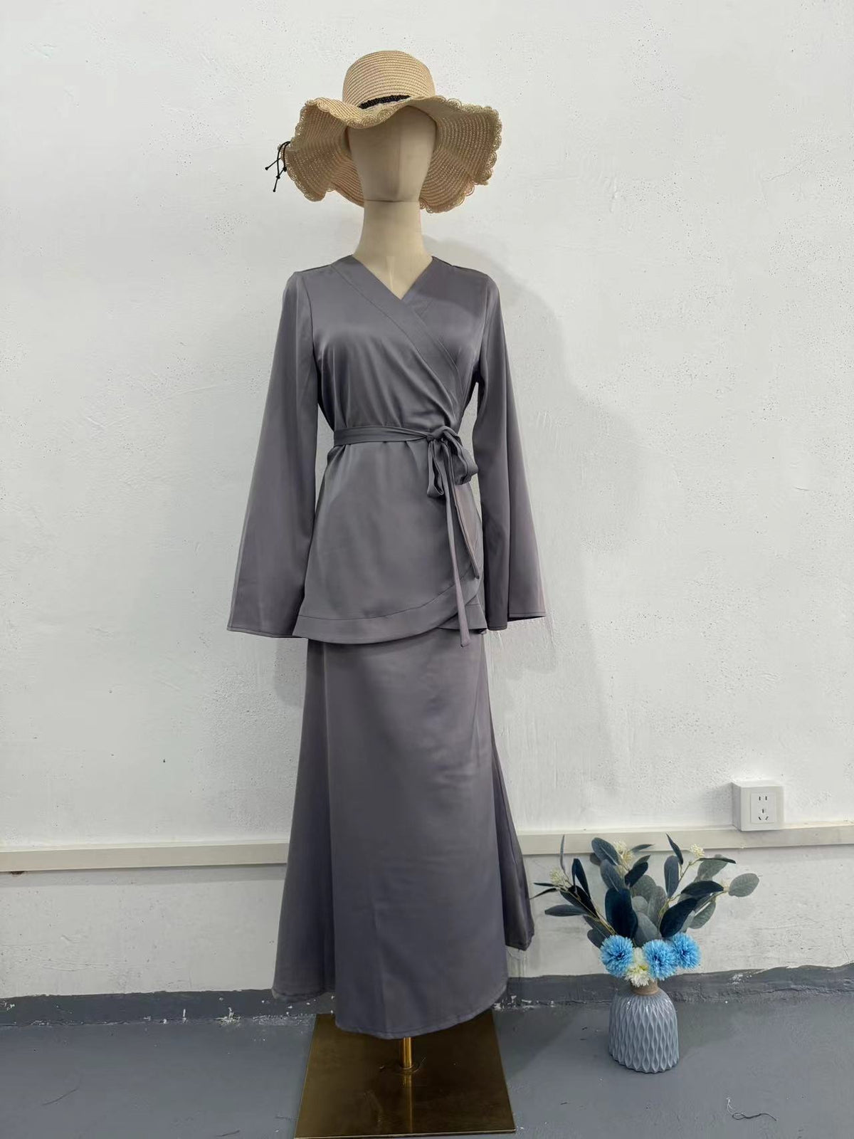 Three-quarter view of burgundy long dress suit worn with accessories