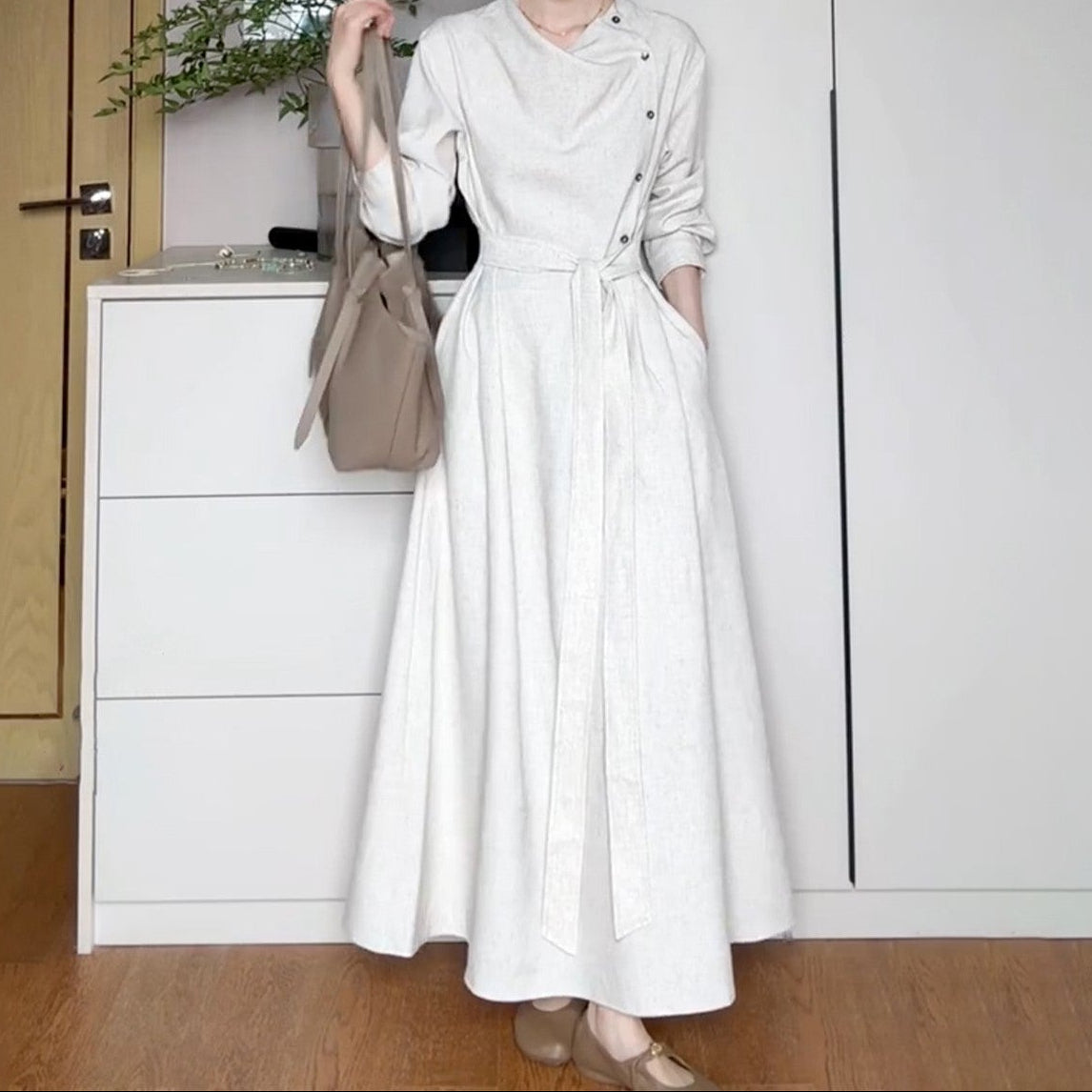 Back view of white long sleeve dress showing graceful draping and hem