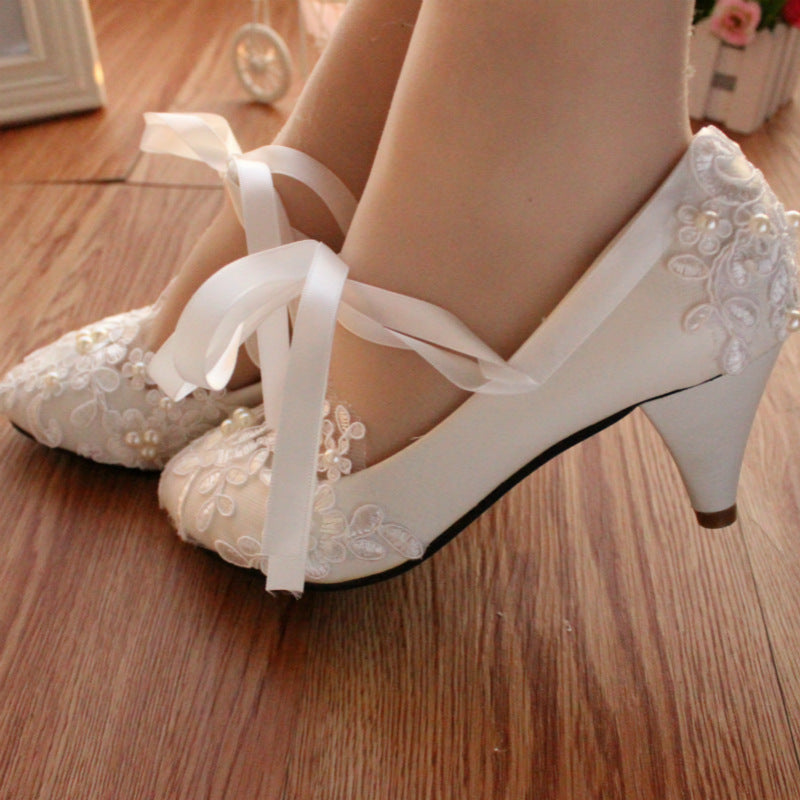 Back view of white lace wedding shoe displaying detailed lacework and construction