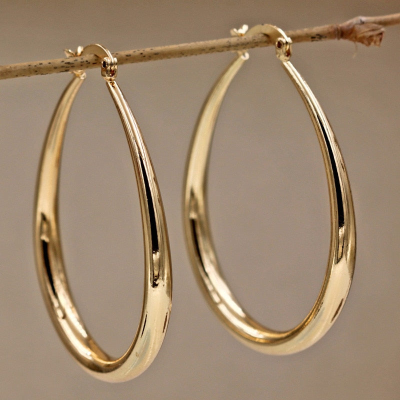 Gold geometric oval earrings with polished finish, elegant accessory for everyday wear