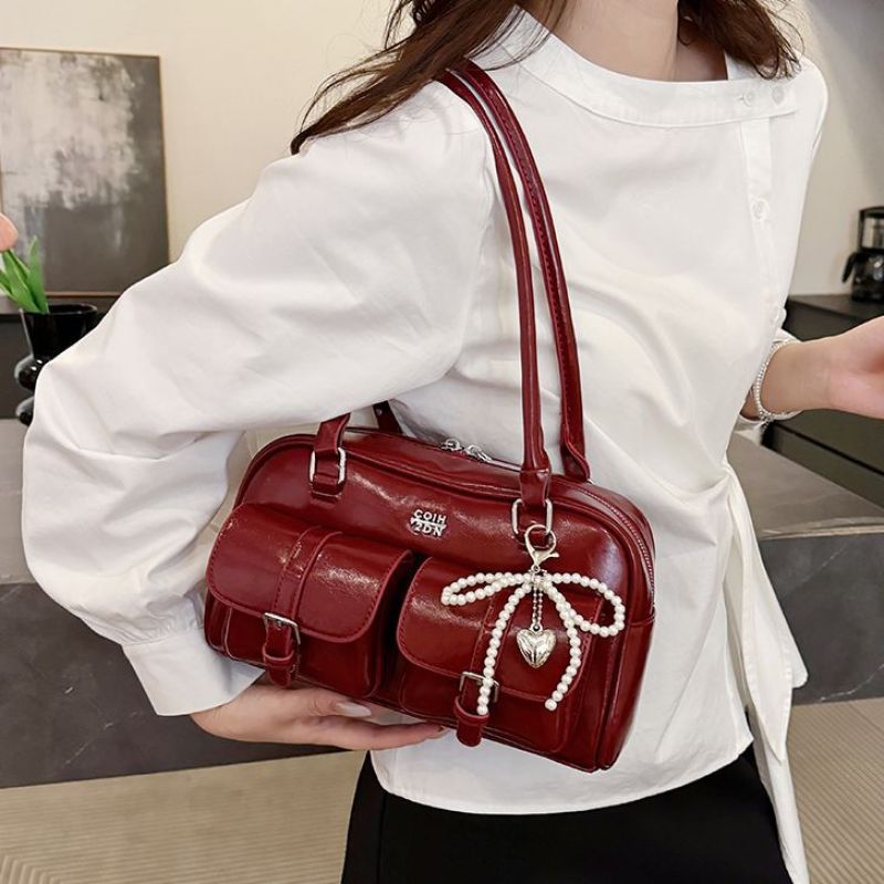 Side profile of shoulder bag displaying compact structured shape and depth