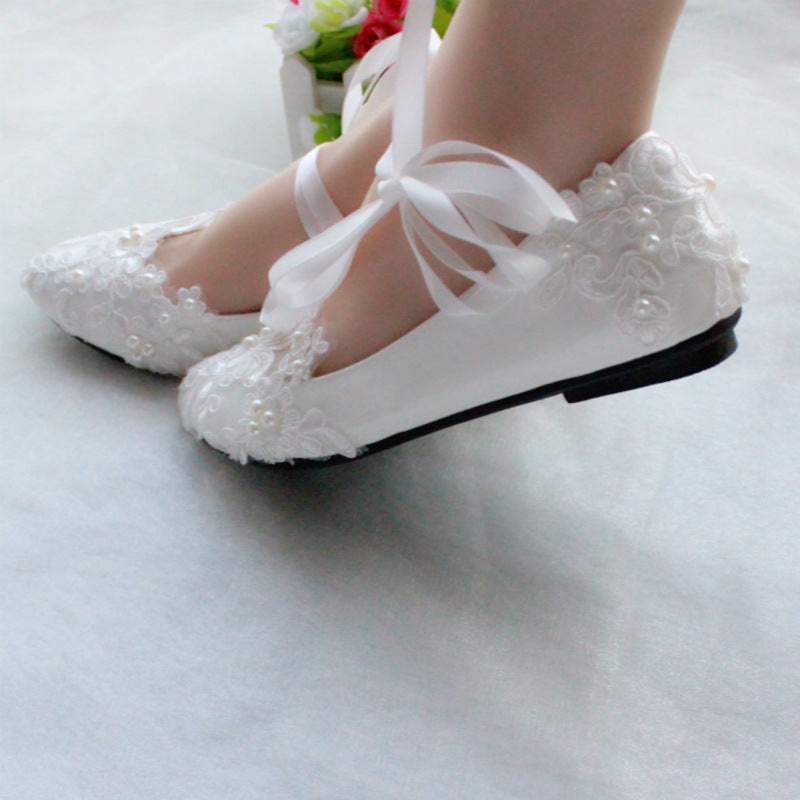 Top-down view of white lace bridal shoe showing full embroidered design pattern