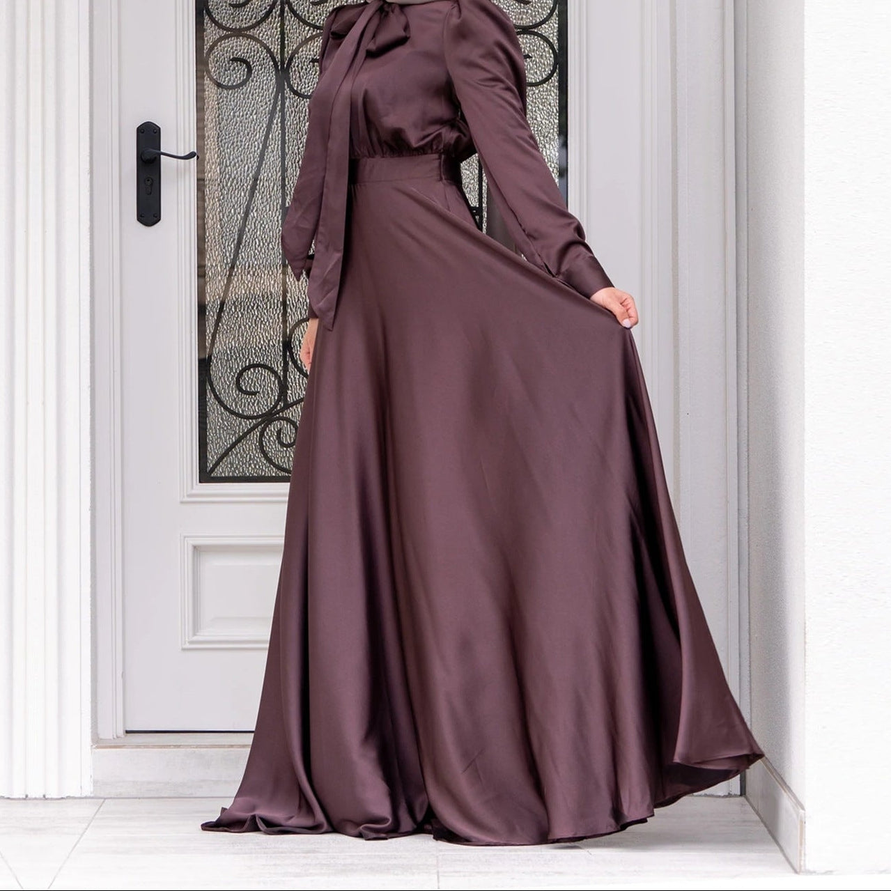 Detail shot of dress hem and lower skirt showing satin sheen and flowing movement