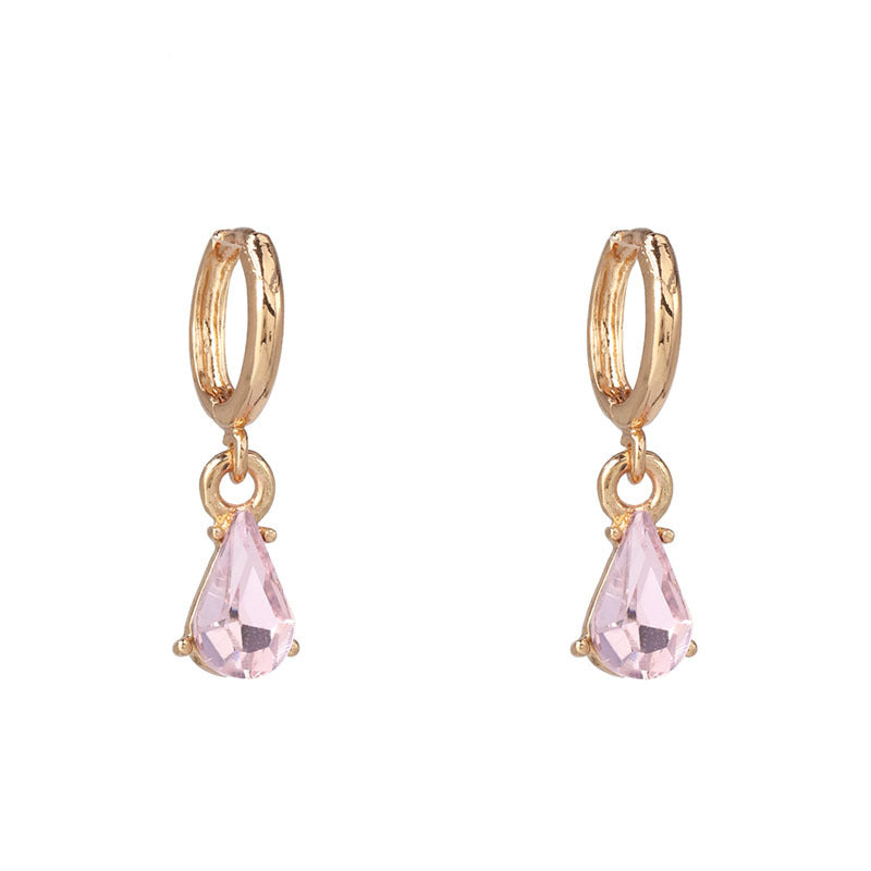 Overhead view of pair of gold glitter earrings on white background