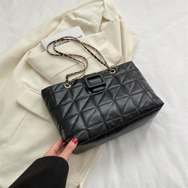 Three-quarter angle view of black chain shoulder bag on white background