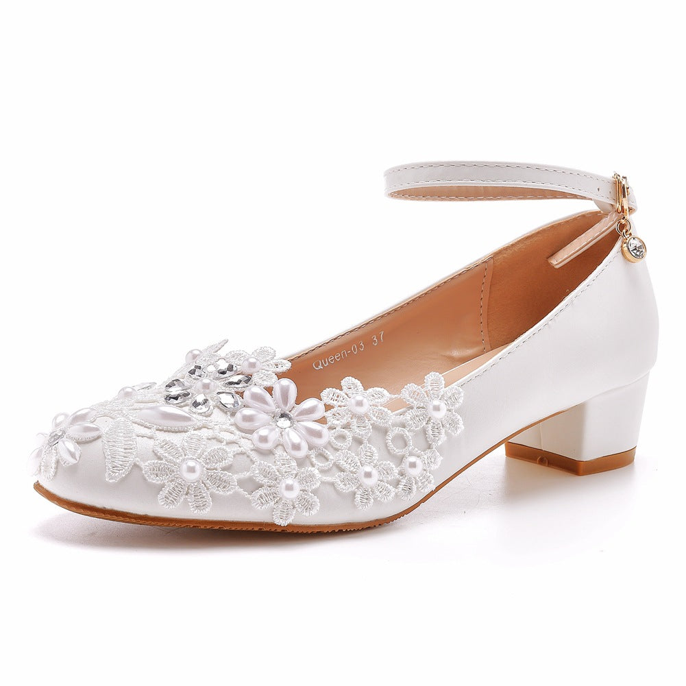 Top-down view of white lace bridal shoe sole and construction