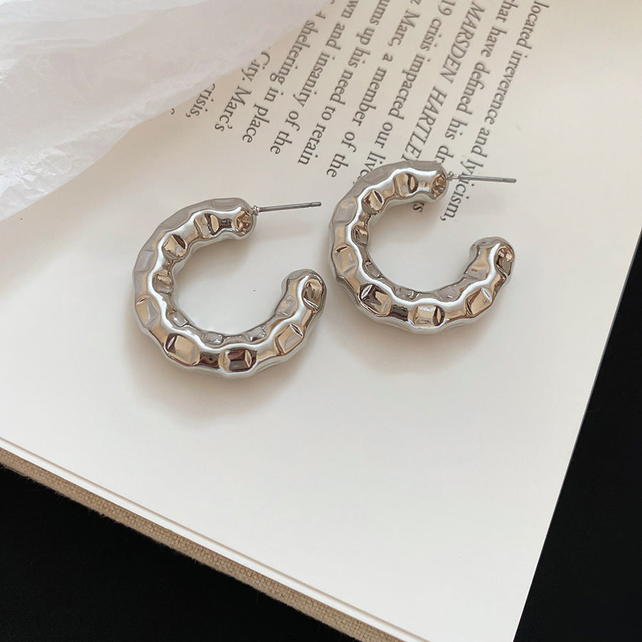 Front-facing view of paired silver hoop earrings displayed together