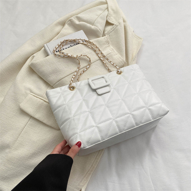 Flat lay of black chain shoulder bag with chain strap fully extended