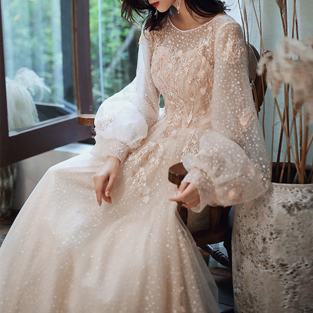 Side profile displaying floor-length skirt silhouette and sleeve construction