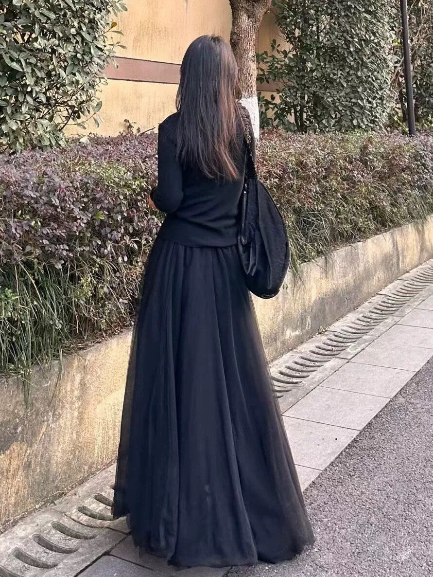 Back view of black midi skirt showing graceful drape and hem length