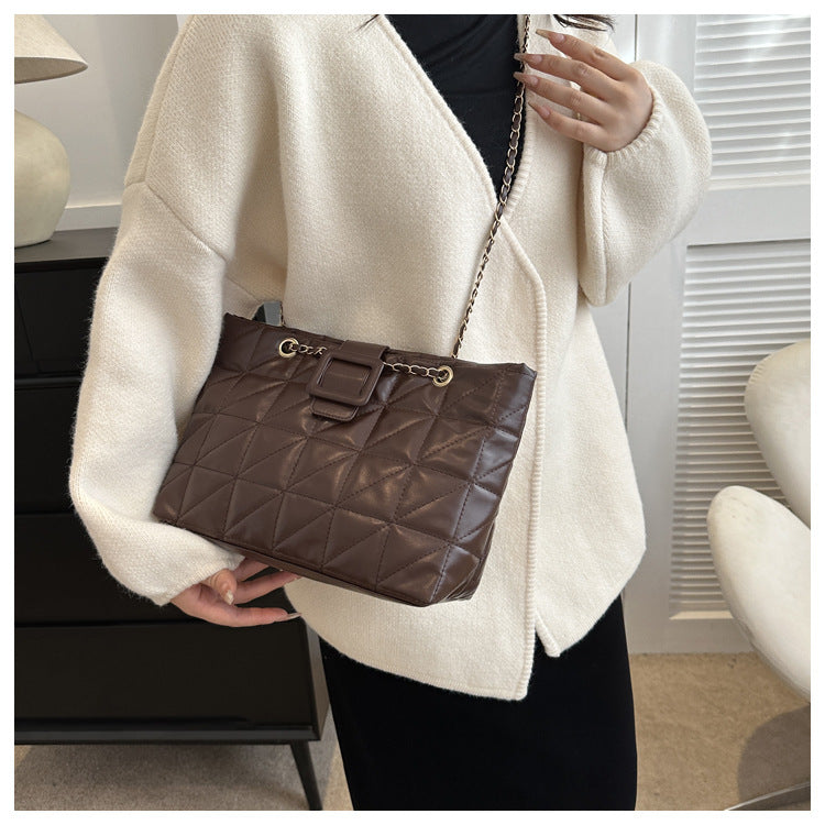 Side profile of black chain shoulder bag with curved body shape