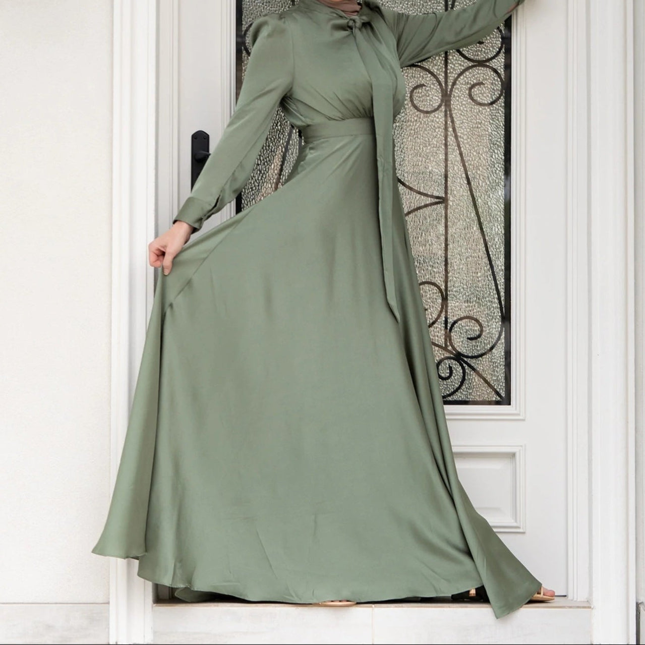 Side profile of satin dress highlighting graceful neckline and sleeve construction