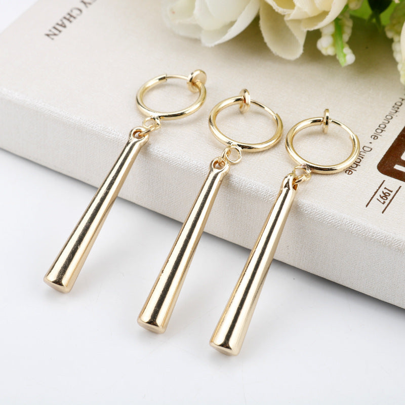 Front-facing view of paired gold drop earrings worn together