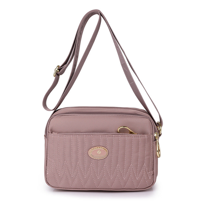 Lifestyle shot of black crossbody bag styled with neutral wardrobe pieces