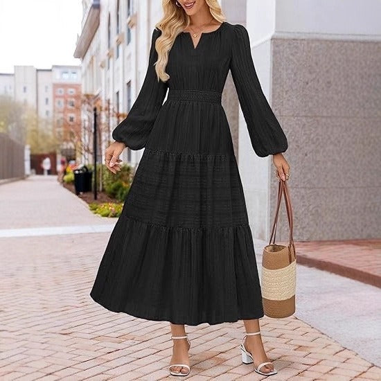 Side profile of black dress with voluminous puffed sleeves and flowing skirt